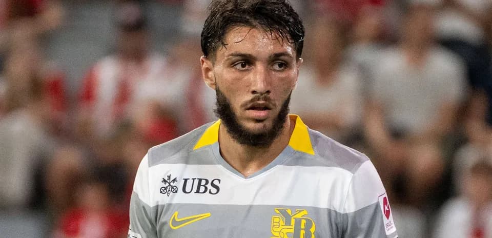 Jugador con camiseta gris y amarilla en el campo
