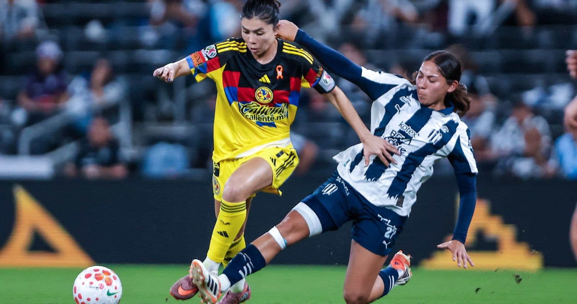 Jugadora de América W driblando a Monterrey W