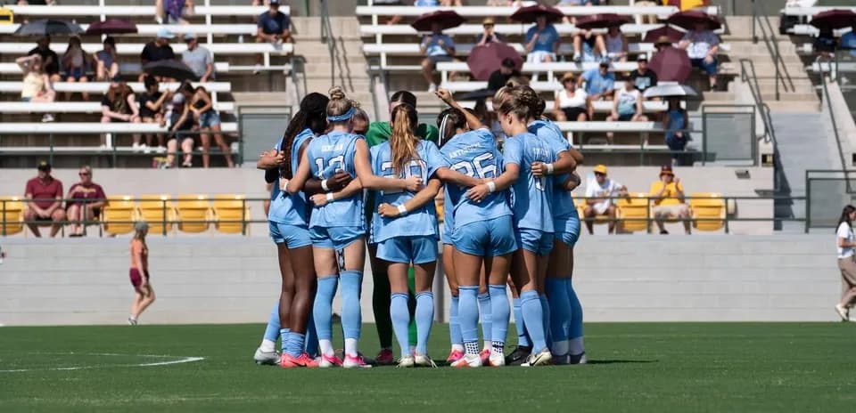 Equipo femenino en círculo antes del partido