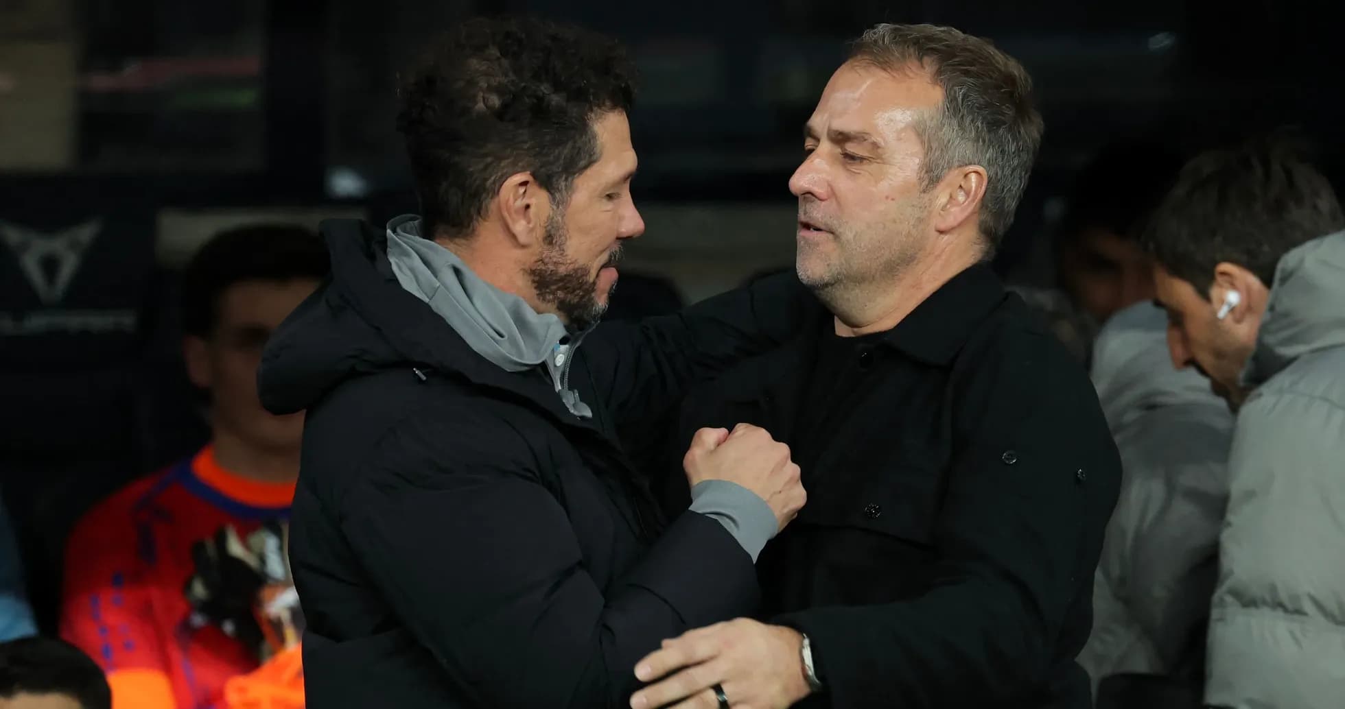 Entrenadores abrazándose en la banca durante el partido
