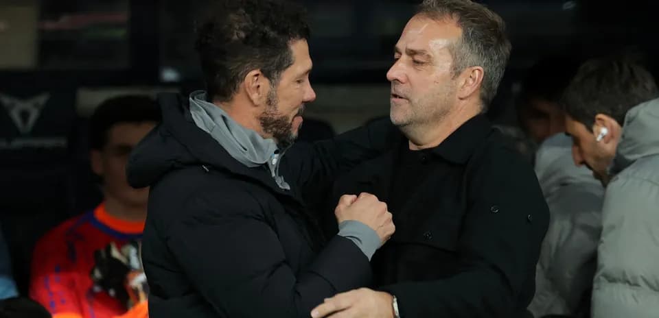 Entrenadores abrazándose en la banca durante el partido