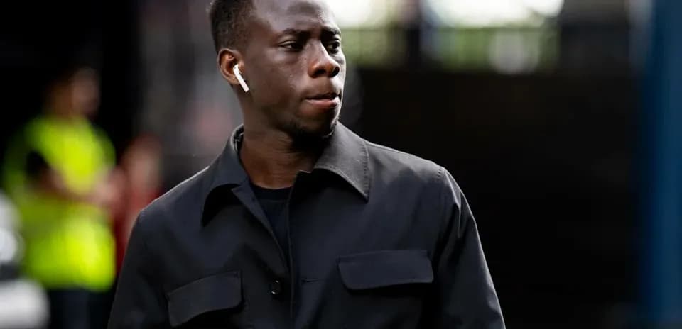 Jugador caminando con auriculares en un estadio
