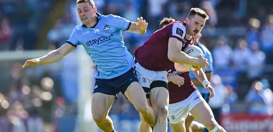 Jugador de Galway corriendo con el balón, defensa de Dublín