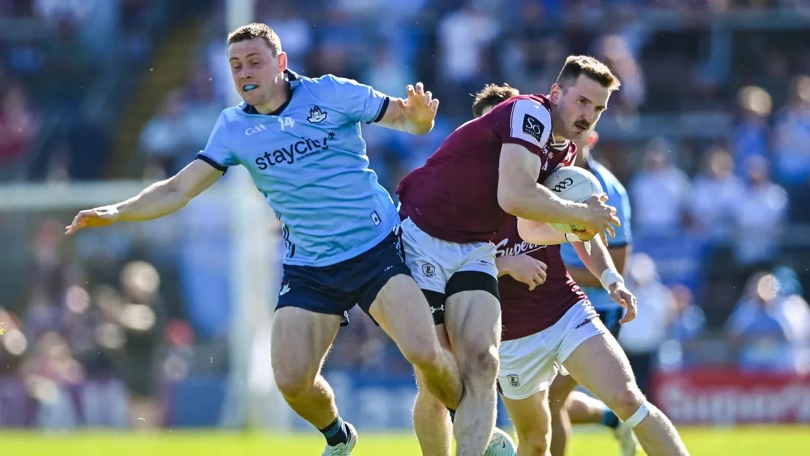 Jugador de Galway corriendo con el balón, defensa de Dublín