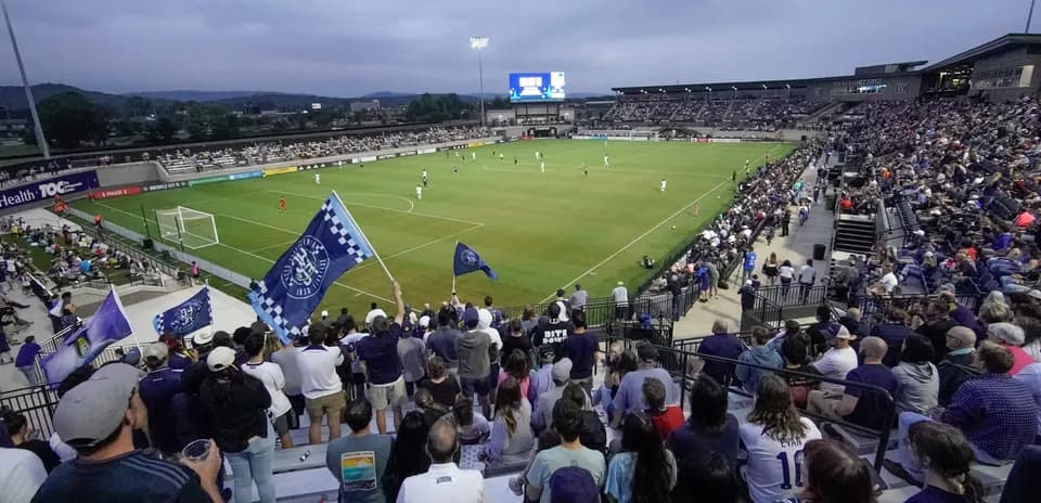 Aficionados animando en partido de fútbol