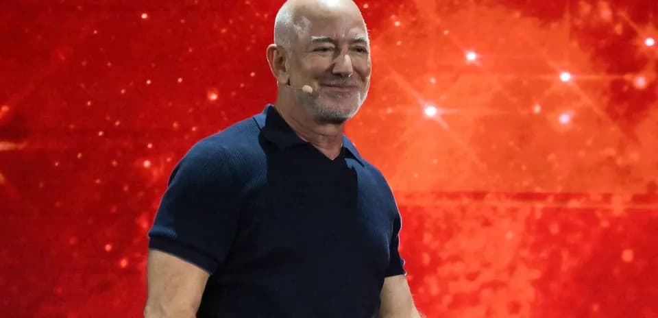 Hombre con micrófono sonriendo en fondo rojo