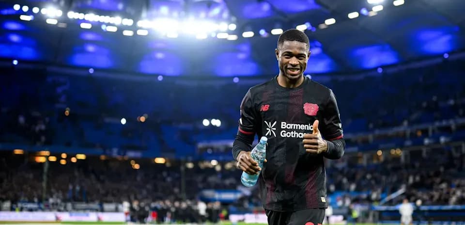Jugador sonriendo y sosteniendo agua en el campo