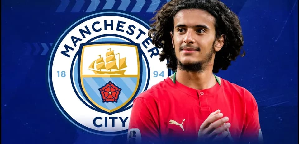 Jugador con camiseta roja frente al logo de Manchester City