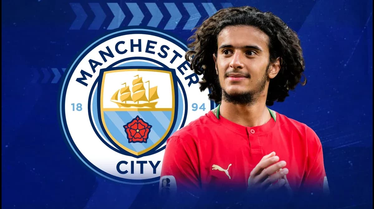 Jugador con camiseta roja frente al logo de Manchester City