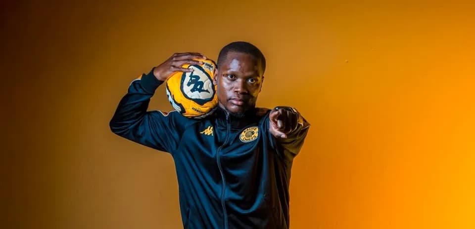 Jugador sosteniendo un balón de fútbol con una mano