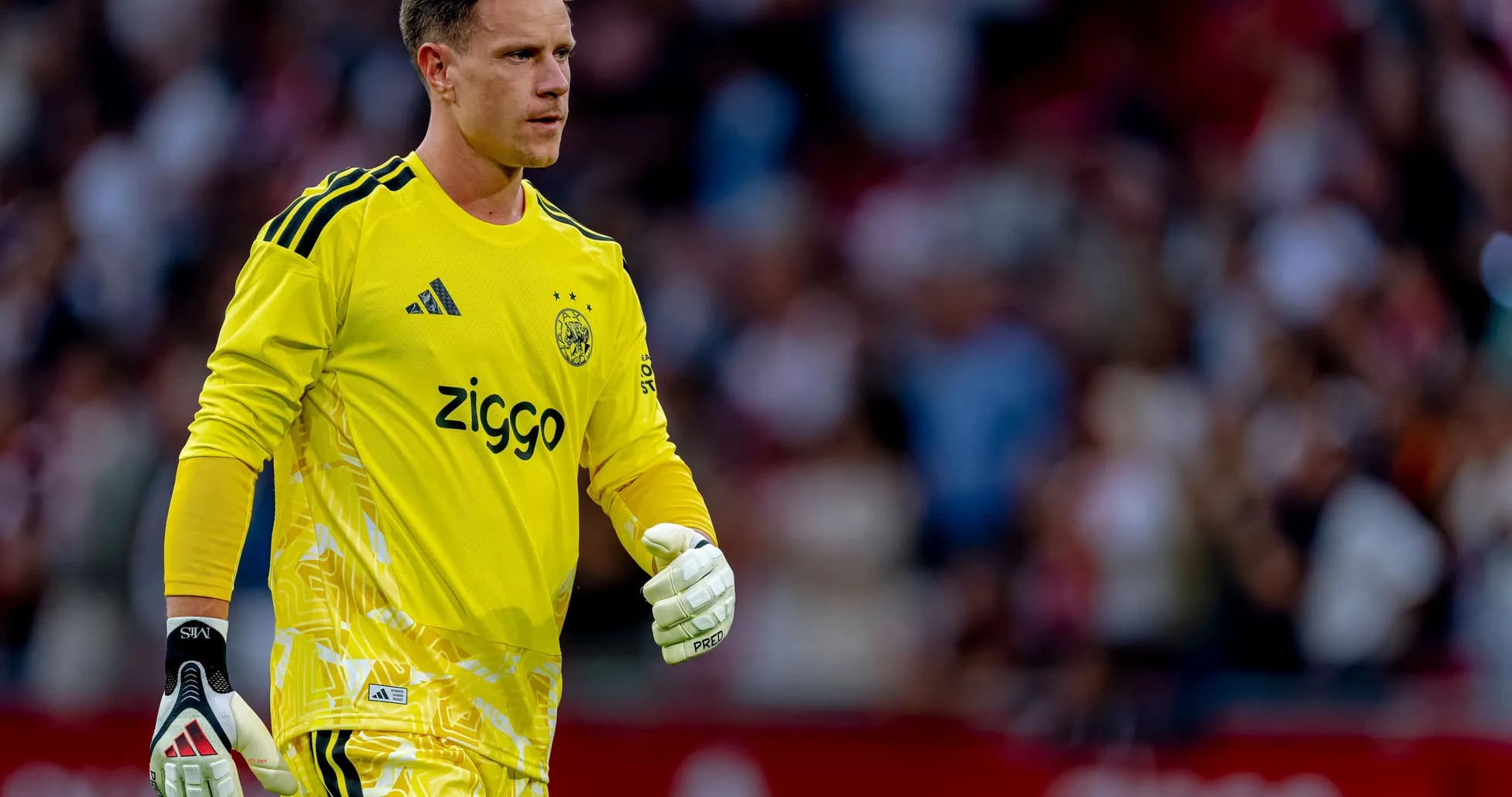 Portero de Ajax con uniforme amarillo en el campo