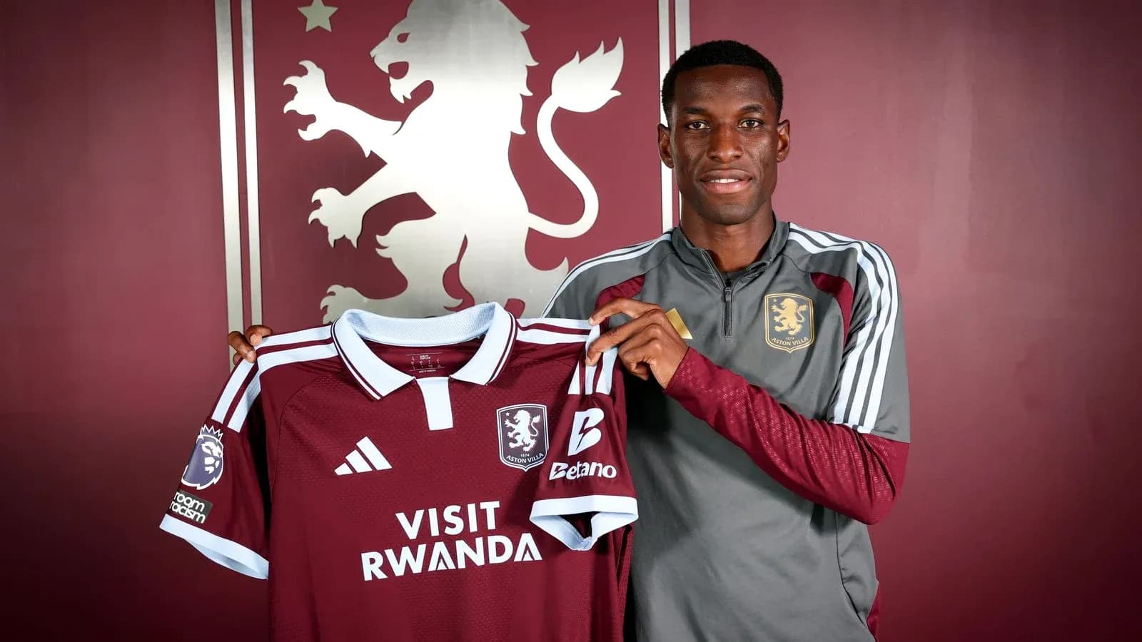 Jugador sosteniendo camiseta de Aston Villa en presentación