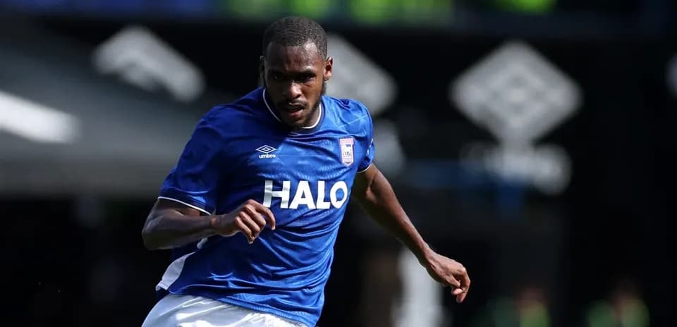Jugador corriendo con balón en camiseta azul