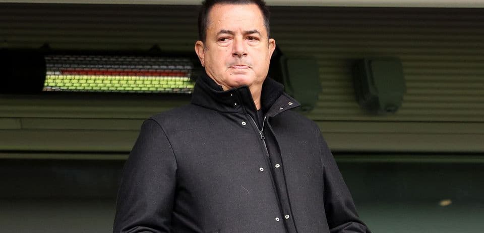 Hombre en abrigo negro observando desde la tribuna