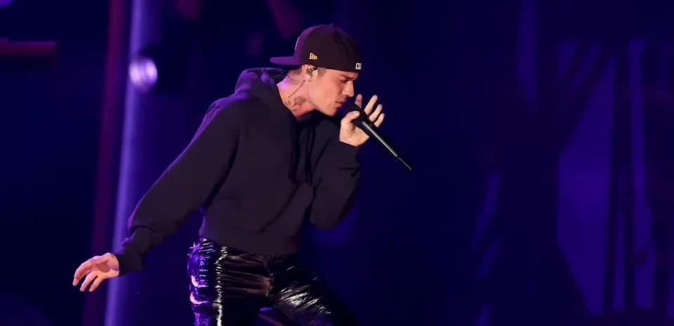 Artista cantando en un escenario con micrófono