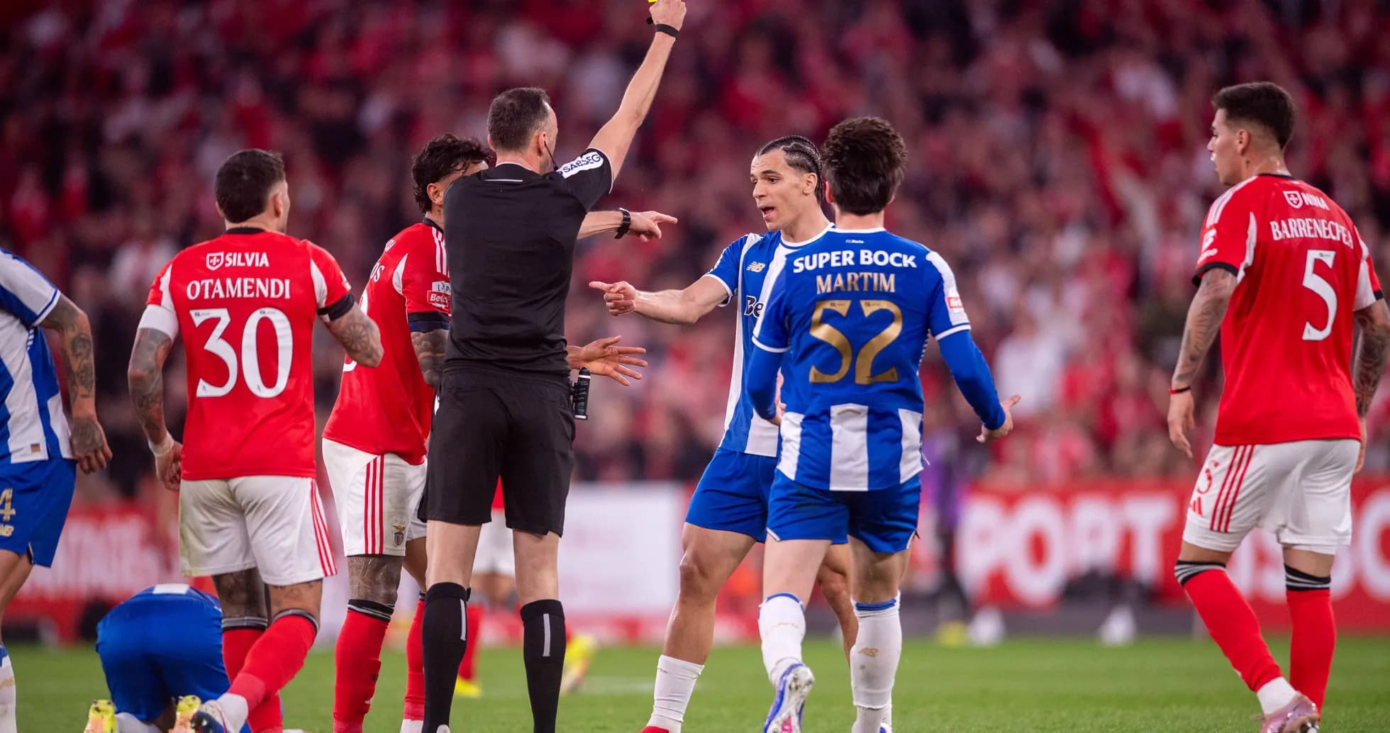 Árbitro mostrando tarjeta amarilla durante el partido