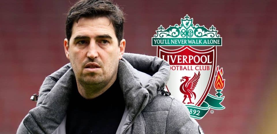 Entrenador de fútbol frente al escudo del Liverpool