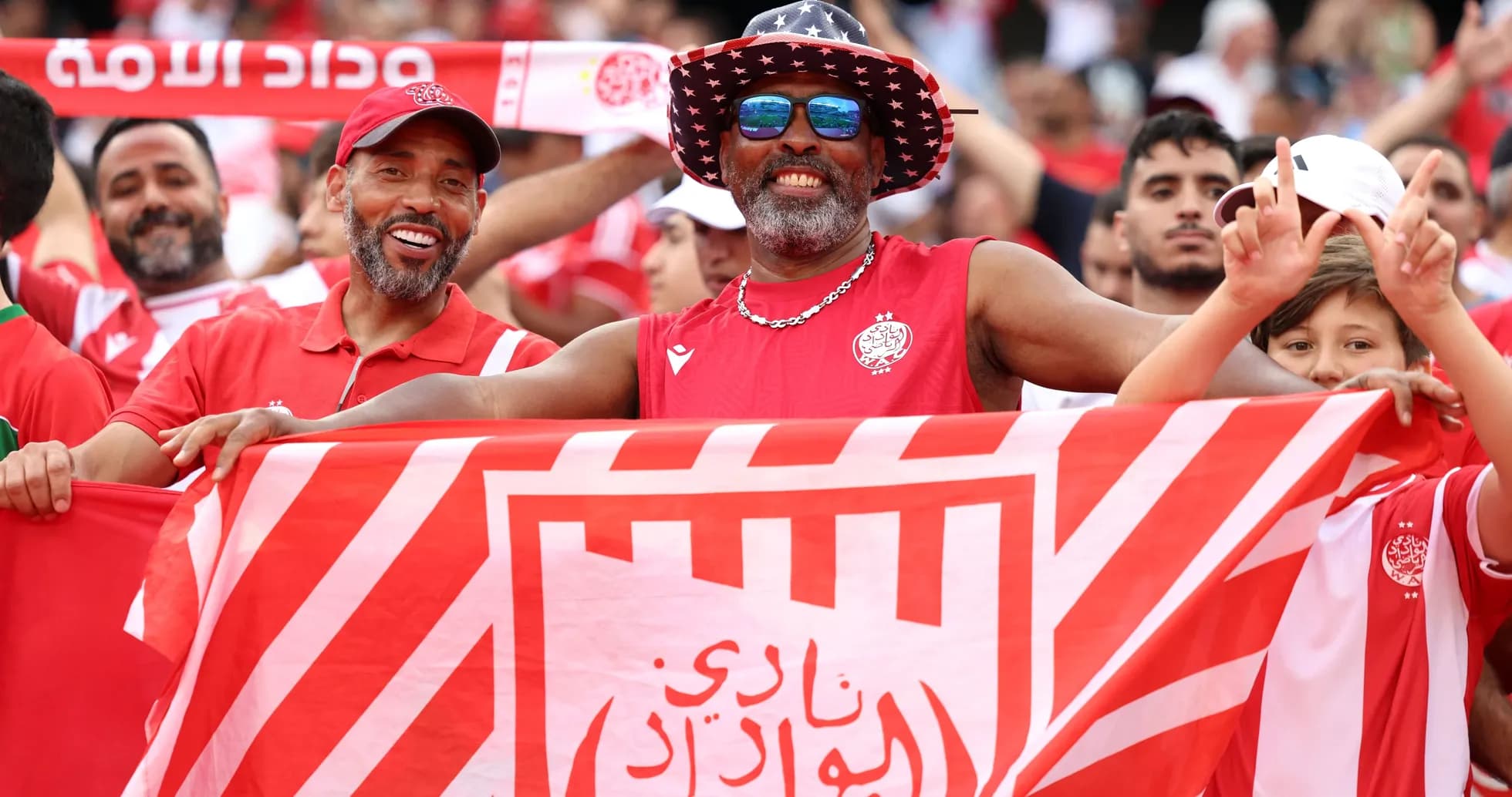 Aficionados con banderas animando en el estadio