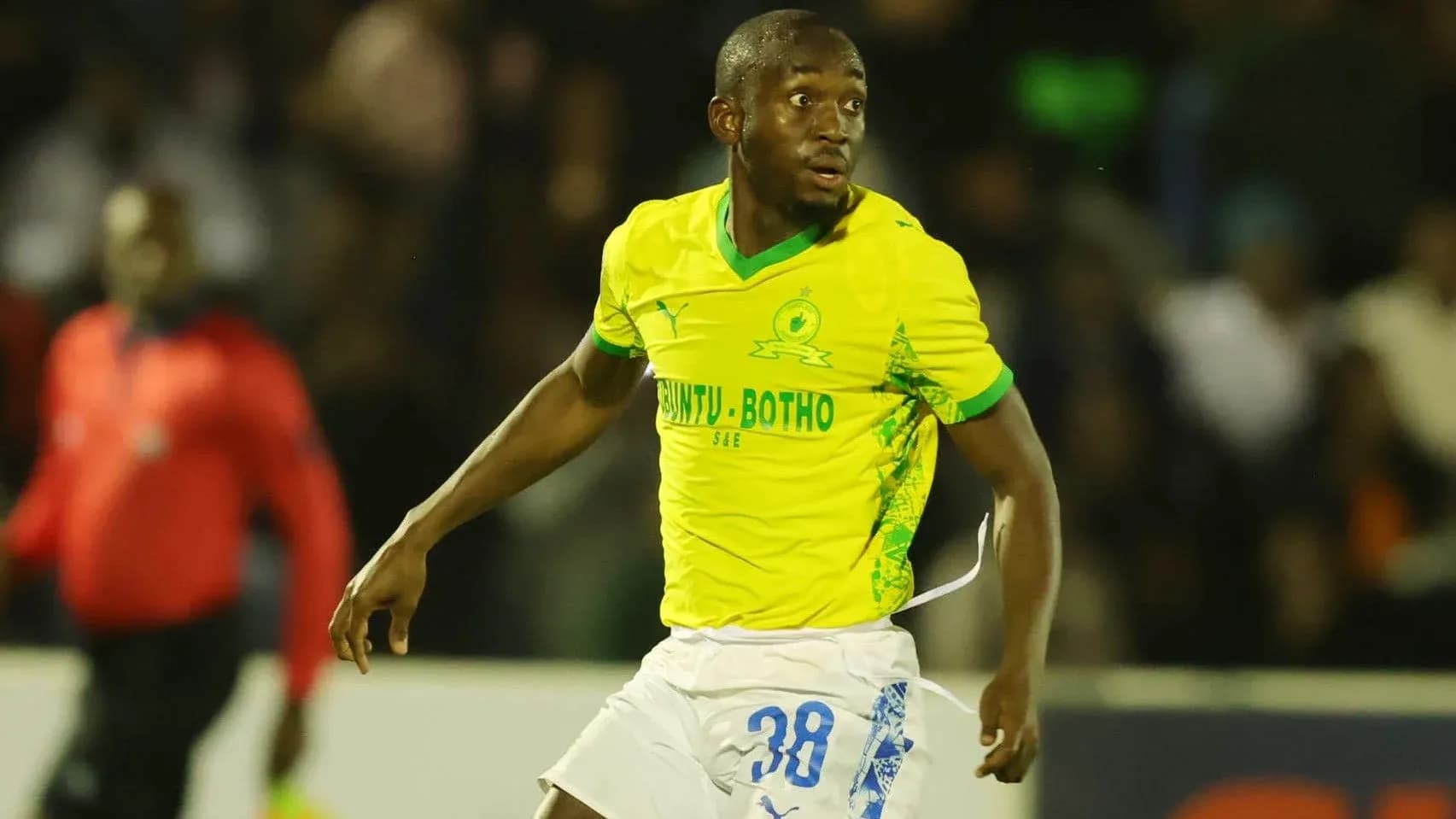 Jugador de fútbol corriendo en camiseta amarilla