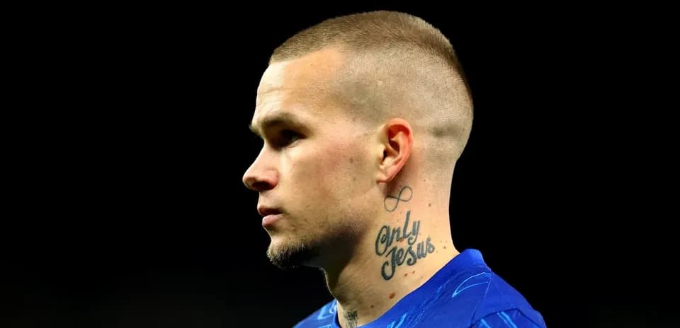 Jugador de fútbol en camiseta azul, perfil lateral