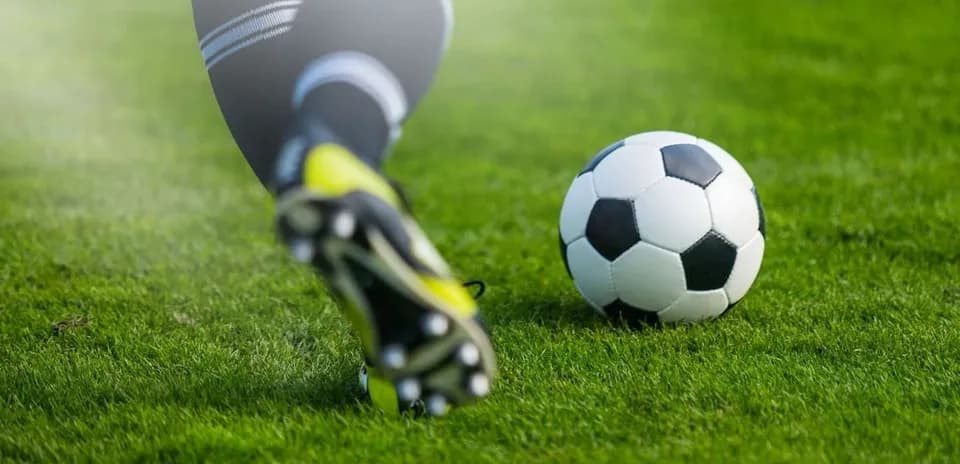 Jugador golpeando el balón de fútbol en el campo
