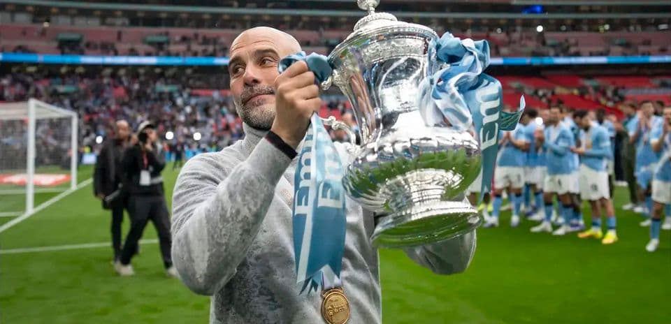 Entrenador levantando trofeo en el estadio Wembley