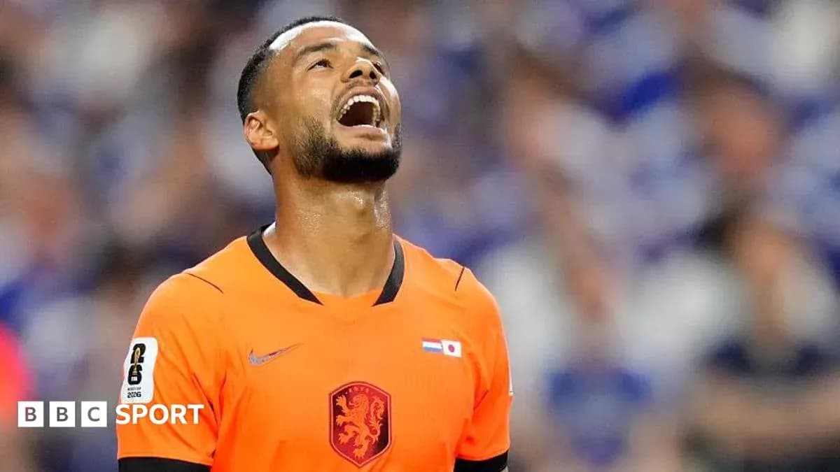 Jugador de fútbol con camiseta naranja mirando hacia arriba