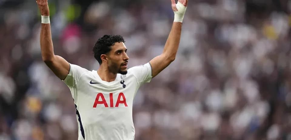 Jugador de Tottenham levantando las manos en el campo