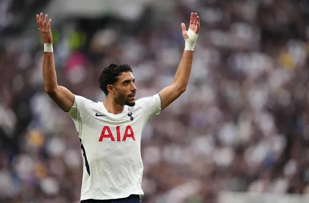 Jugador de Tottenham levantando las manos en el campo
