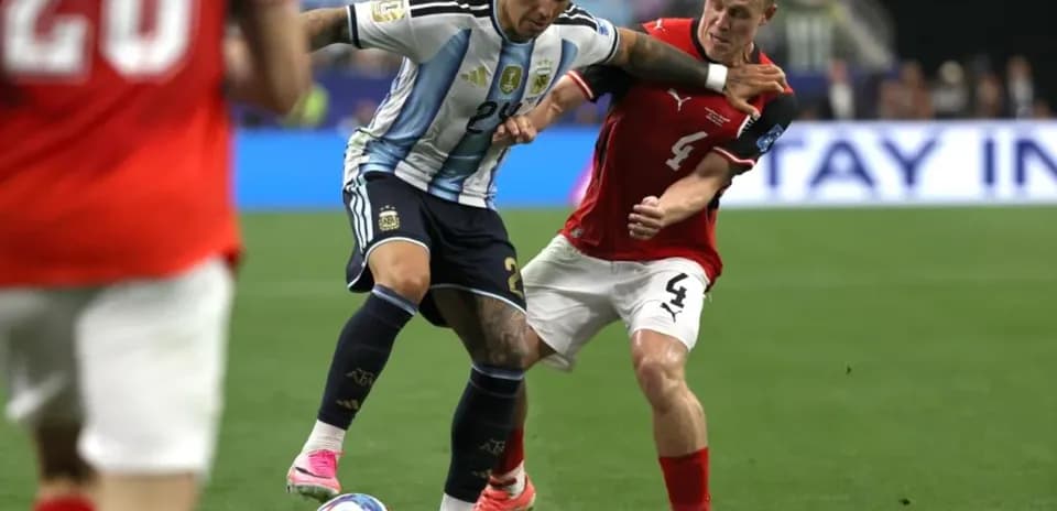Jugador argentino desafiando a defensor austriaco en partido
