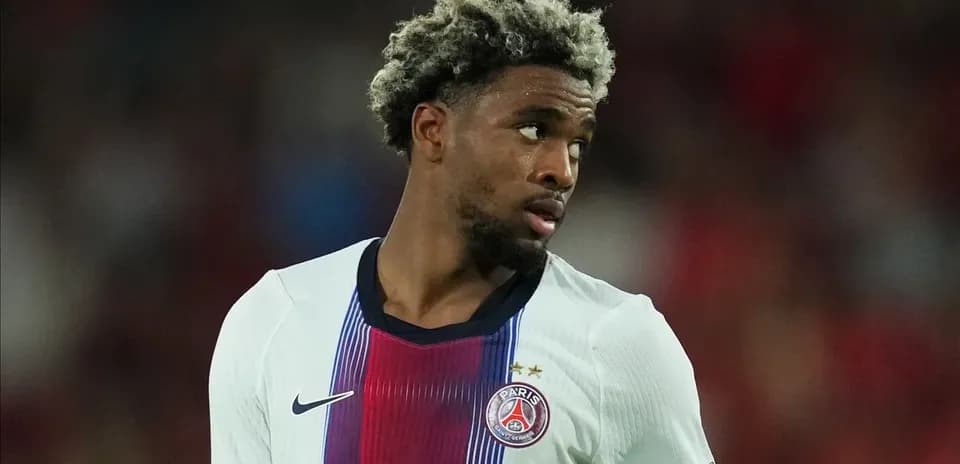 Jugador de PSG con camiseta blanca mirando hacia atrás