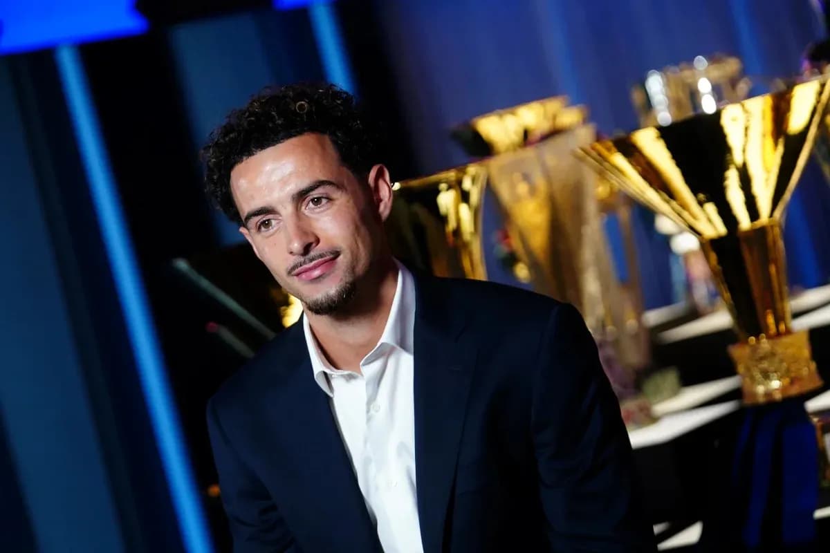 Jugador posando con trofeos en el fondo