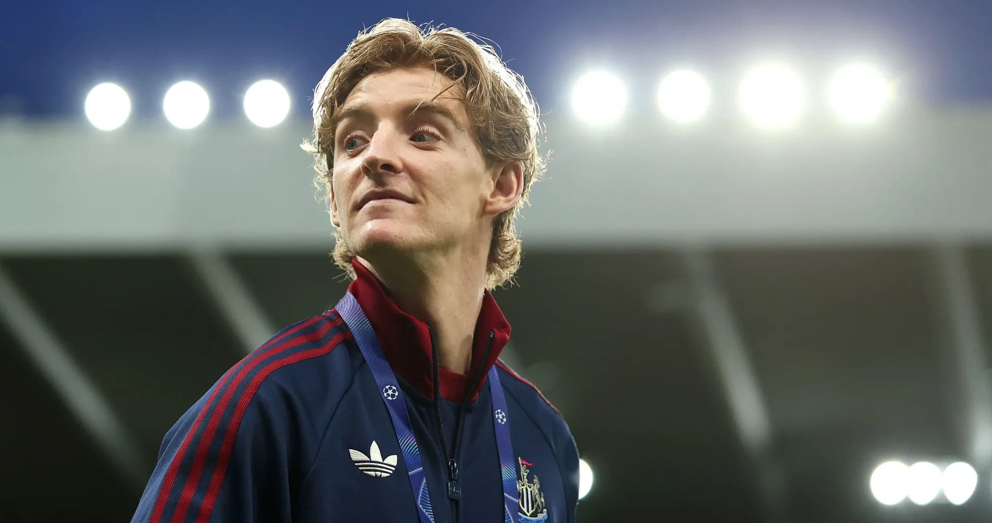 Jugador de Newcastle con chaqueta en el estadio