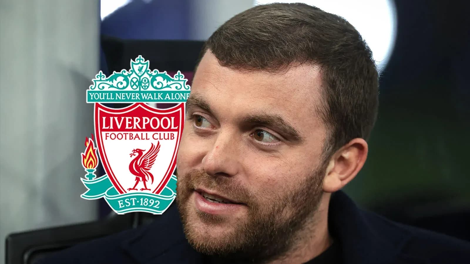 Hombre sonriendo con el logo del Liverpool FC