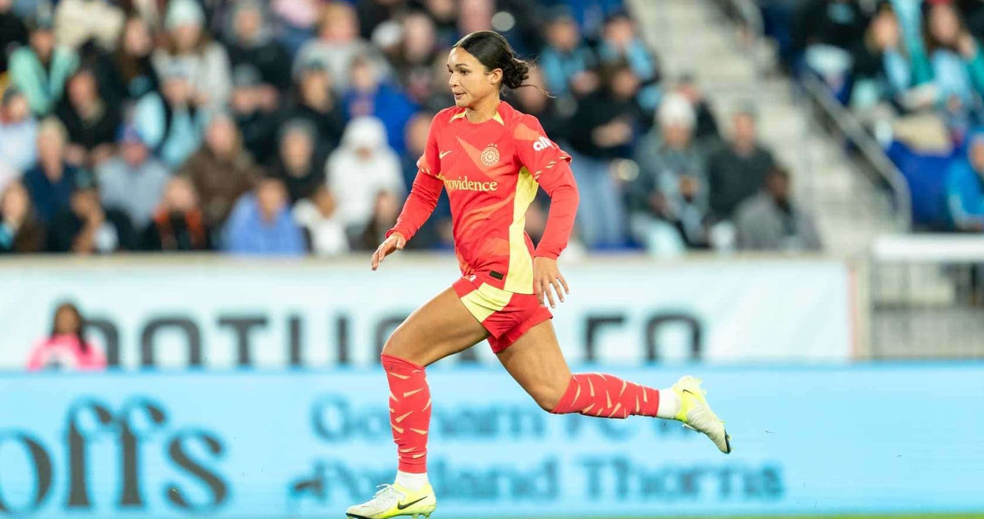 Jugadora corriendo en partido de fútbol femenino