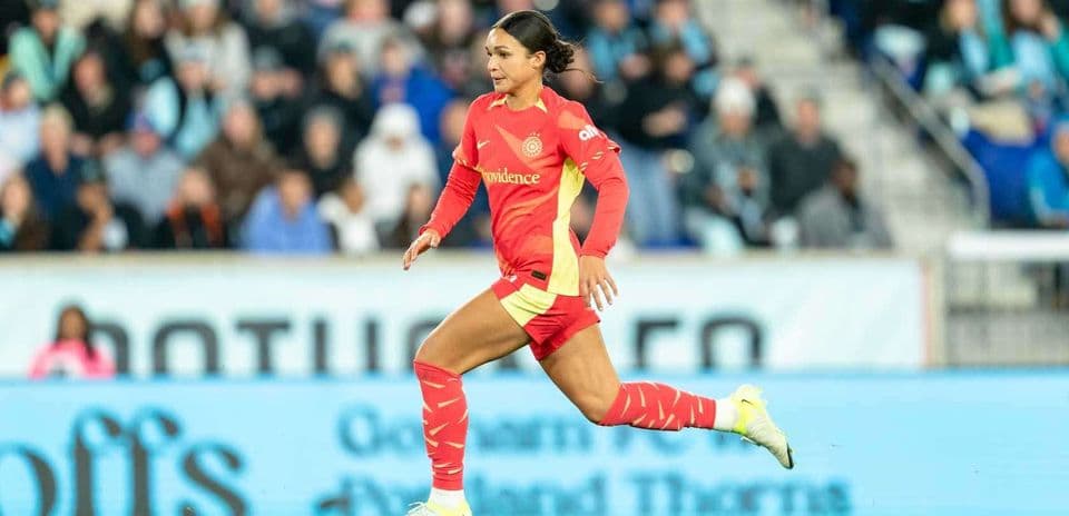 Jugadora corriendo en partido de fútbol femenino