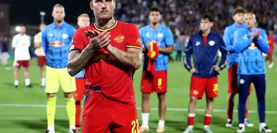 Jugador aplaudiendo con compañeros de equipo detrás