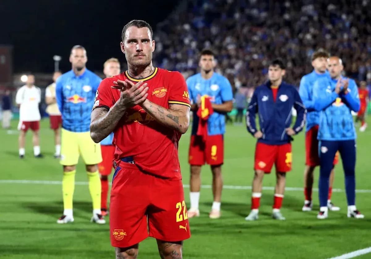 Jugador aplaudiendo con compañeros de equipo detrás