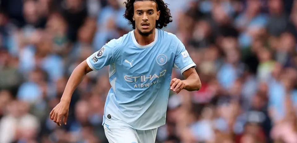 Jugador de Manchester City corriendo con balón en el campo