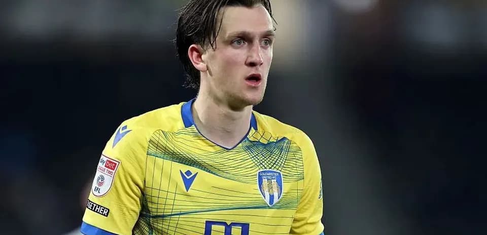Jugador con camiseta amarilla de Colchester United en acción