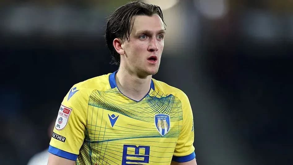 Jugador con camiseta amarilla de Colchester United en acción