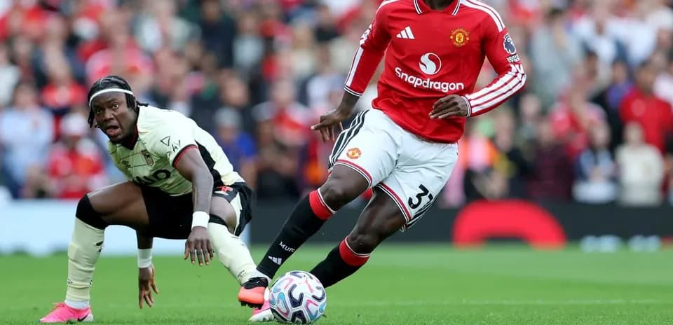 Jugador de Manchester United driblando a rival en partido
