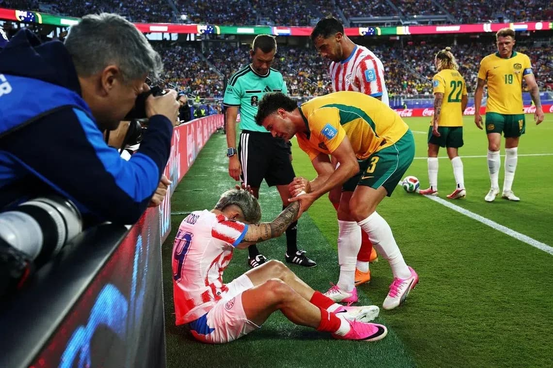 Jugador caído siendo asistido por rival y árbitro