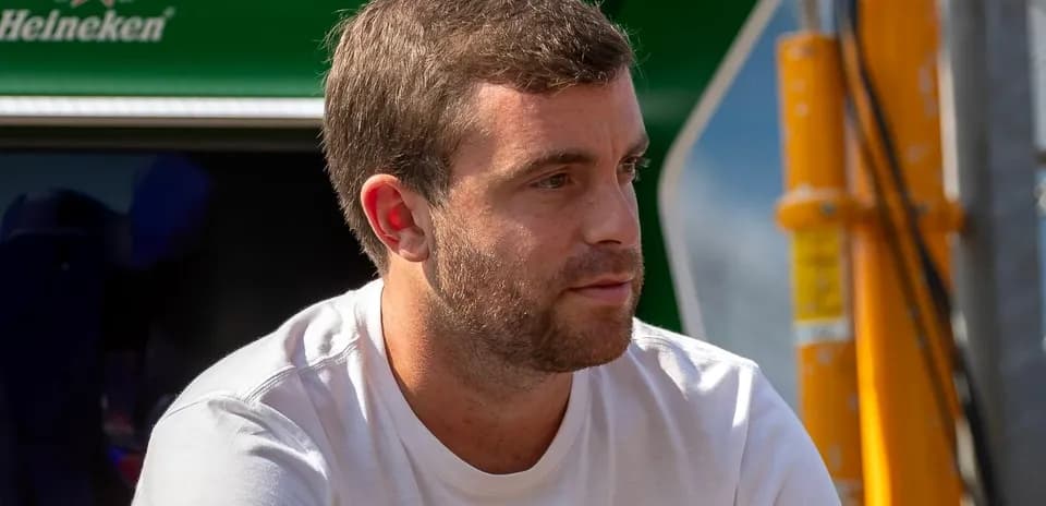 Hombre sentado cerca de un equipo de carrera