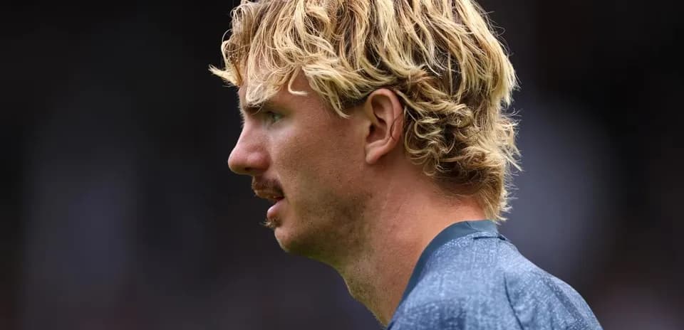 Jugador con cabello rubio y bigote en perfil