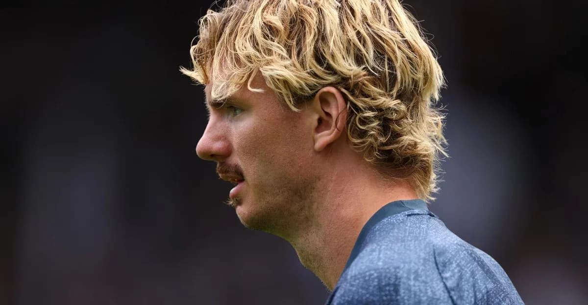 Jugador con cabello rubio y bigote en perfil