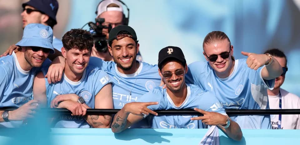 Cinco aficionados de Manchester City sonriendo juntos