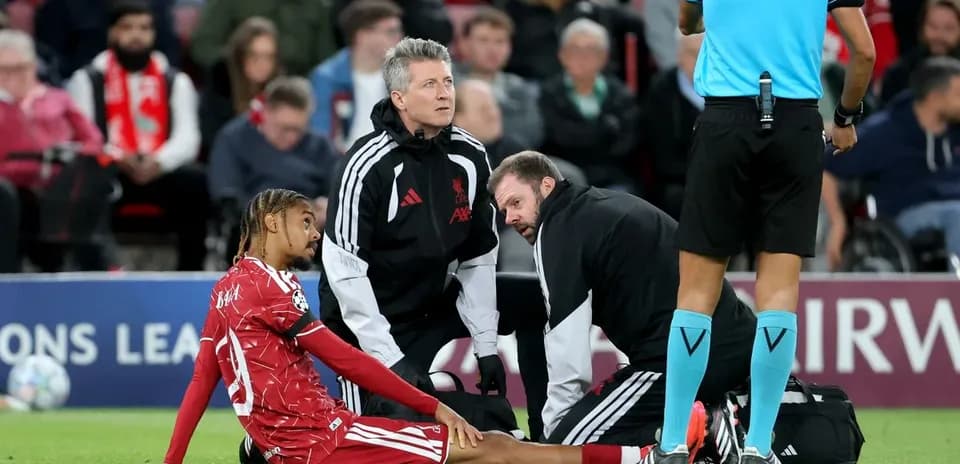 Jugador sentado con personal médico en el campo