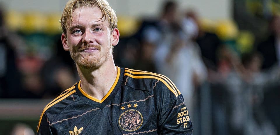 Jugador de Ajax sonriendo en el campo después del partido