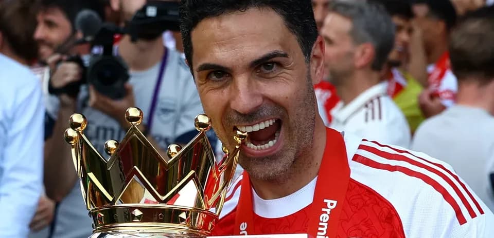 Entrenador sosteniendo trofeo de Premier League en celebración